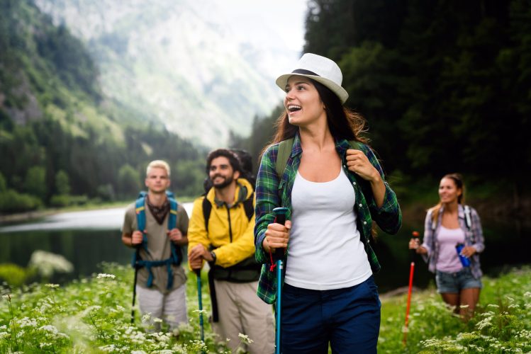 Adventure, travel, tourism, hike and people concept. Group of smiling friends with backpacks outdoors